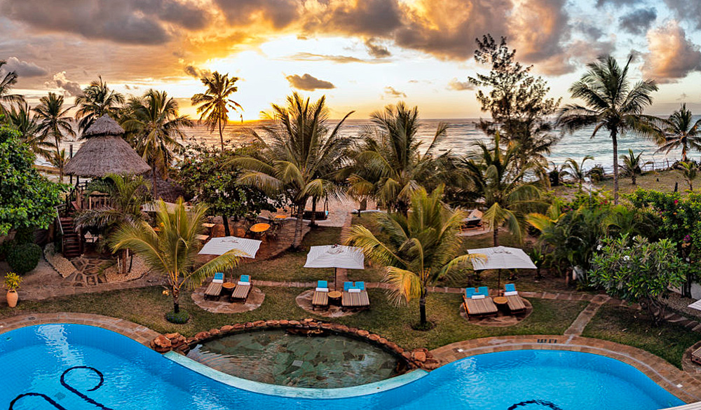Hotel showing swimming pool, palm trees and sea