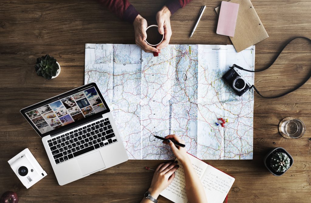 Planning a trip around a map, laptop and camera