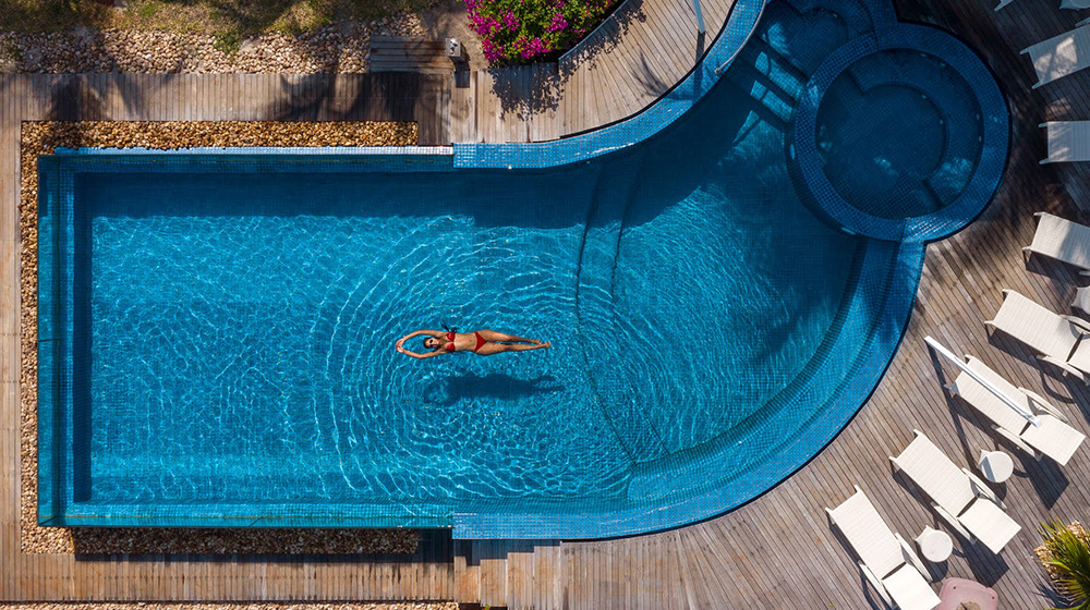 Villa pool with woman swimming wearing red bikini