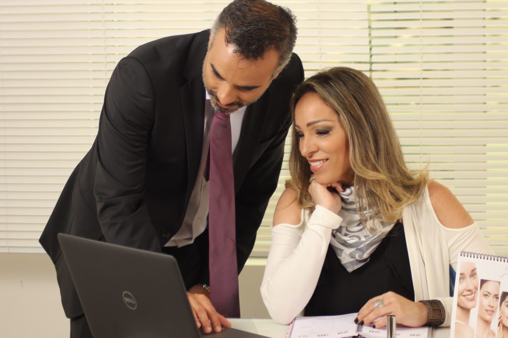 Man and woman office workers look at a laptop