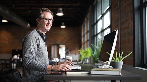 Man at office desk smiling